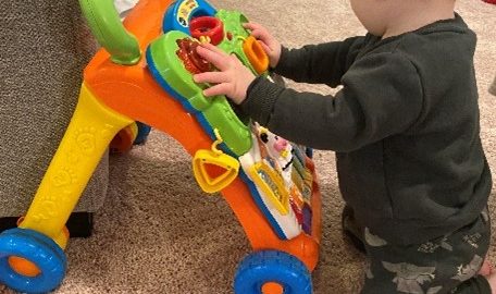 toddler kneeling with slanted toy