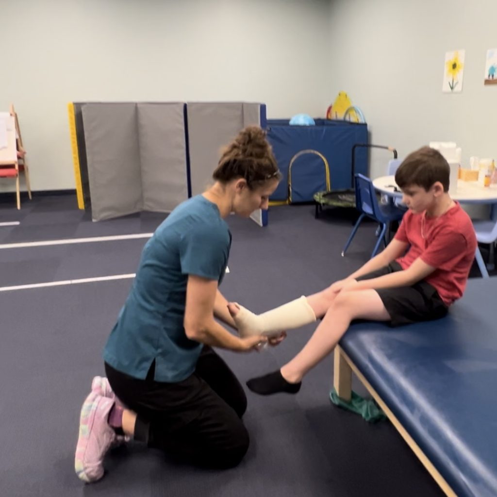 Jenn Jones, PT, DPT, PCS checking serial casting for pediatric physical therapy client in rehabilitation therapy at Savannah Speech & Hearing center