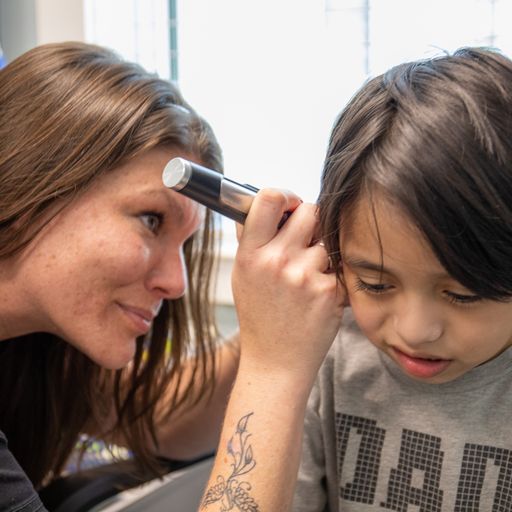 Lauren Alvarado | Audiology Assistant offering hearing screening to a child at Savannah Speech & Hearing Center.