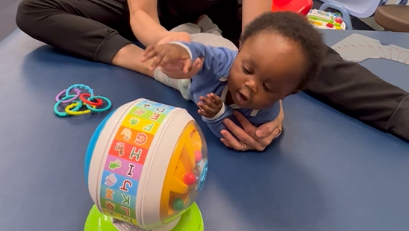 Pediatric PT at Savannah Speech & Hearing Center helping a baby learn to roll