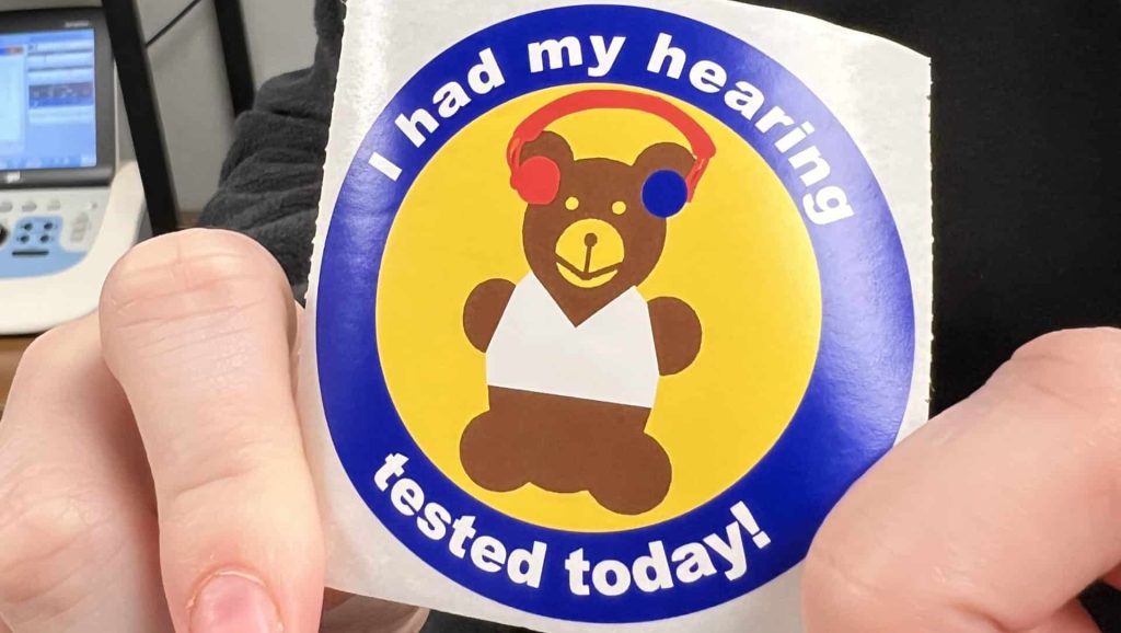 Sticker of bear wearing a headset with caption "I had my hearing tested today!"